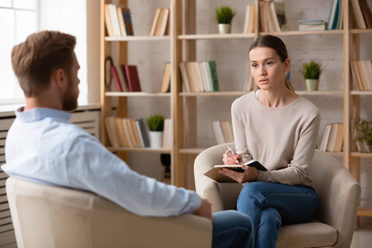 Сеанс терапии: пациент беседует с психологом в реабилитационном центре